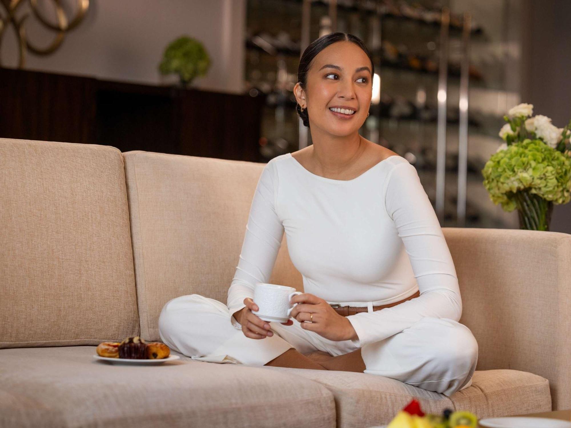 Hotel Fairmont Makati à Makati City Extérieur photo A woman sitting on a sofa